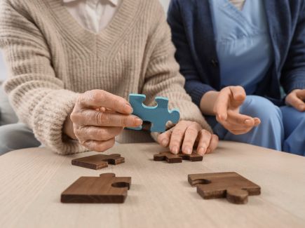 An elderly woman completing a puzzle